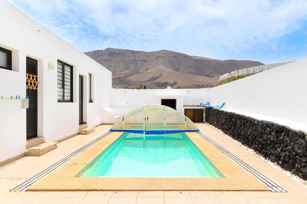 a swimming pool in the middle of a house at Famara Beach Apt in Famara