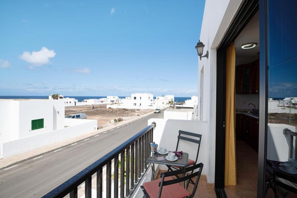 a balcony with chairs and a view of the ocean at Apartamento Fondeo in Tinajo