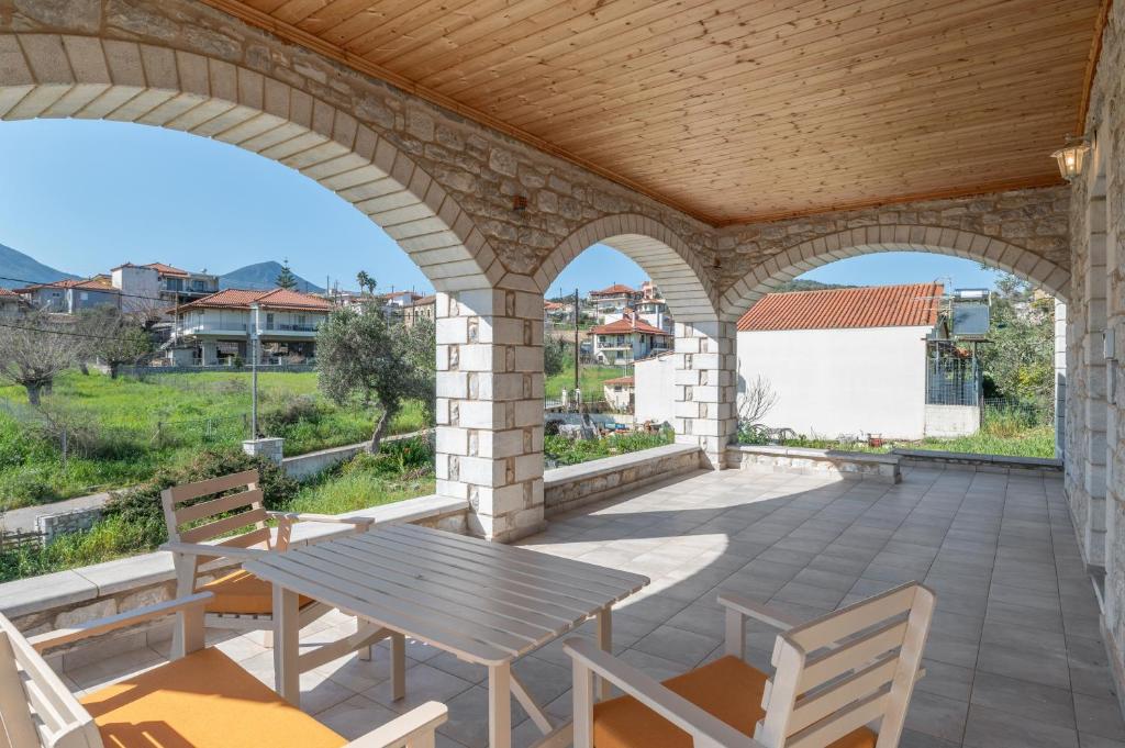 an outdoor patio with a wooden table and chairs at Angelina’s Stone Village House in Valíra