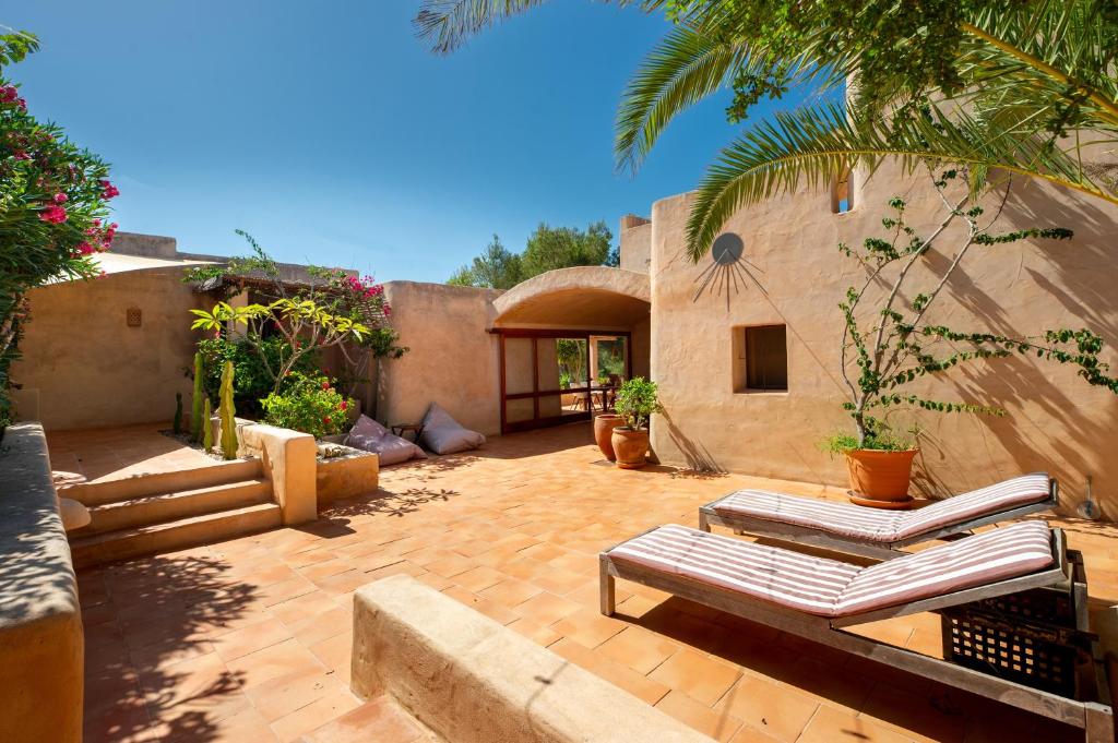 a patio with lounge chairs and a house at Sa Paret Nova in Sant Francesc Xavier