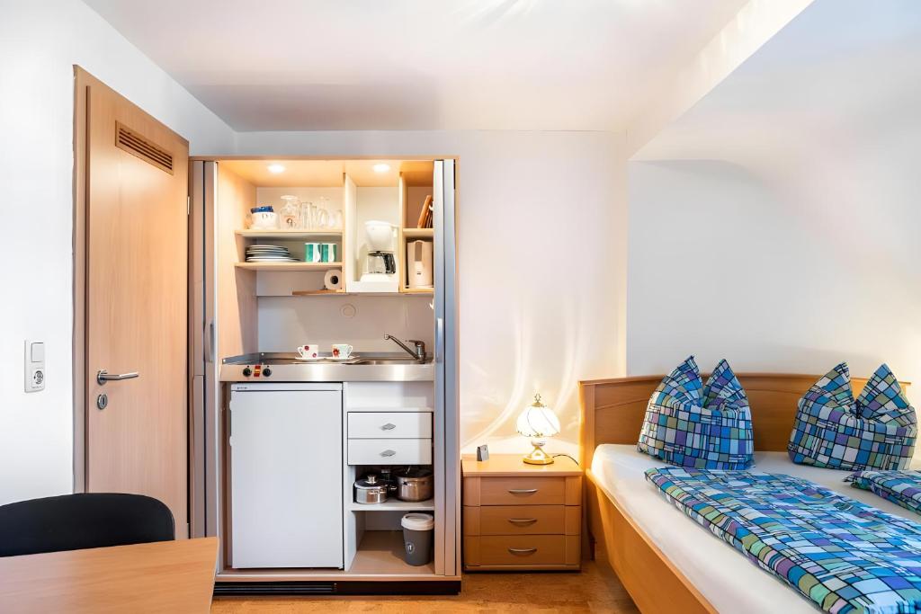 a small bedroom with a bed and a sink at Zimmer Edith in Gersfeld