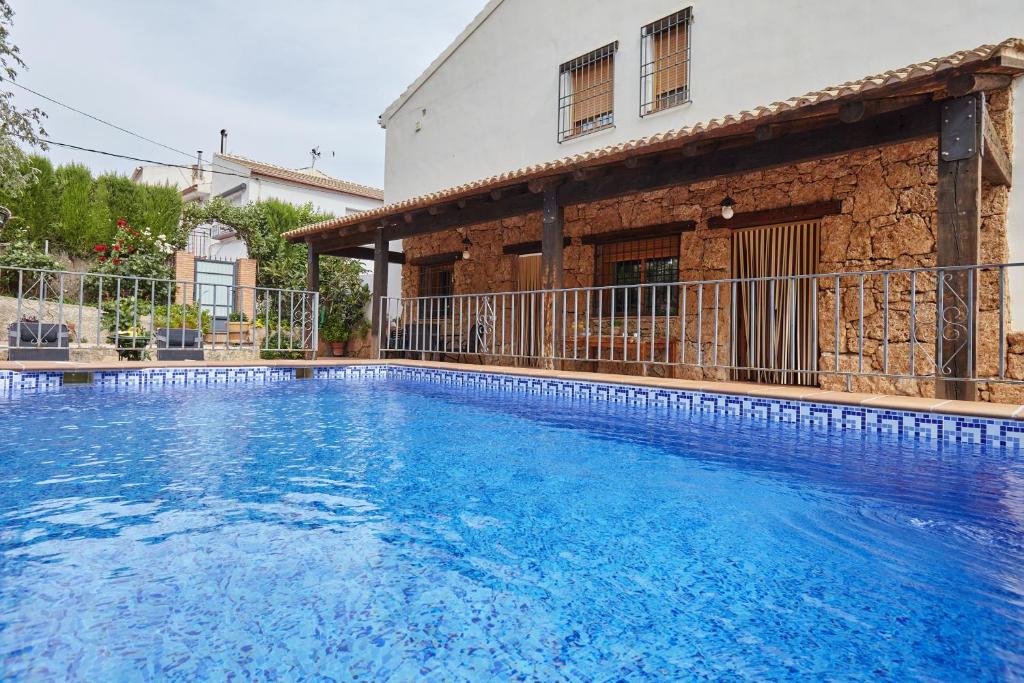 a large swimming pool in front of a house at Alojamiento Rural La Ventilla in Arbuniel