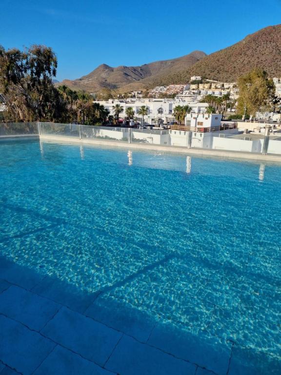 a large pool of blue water with mountains in the background at HOTEL ALOVE in San José
