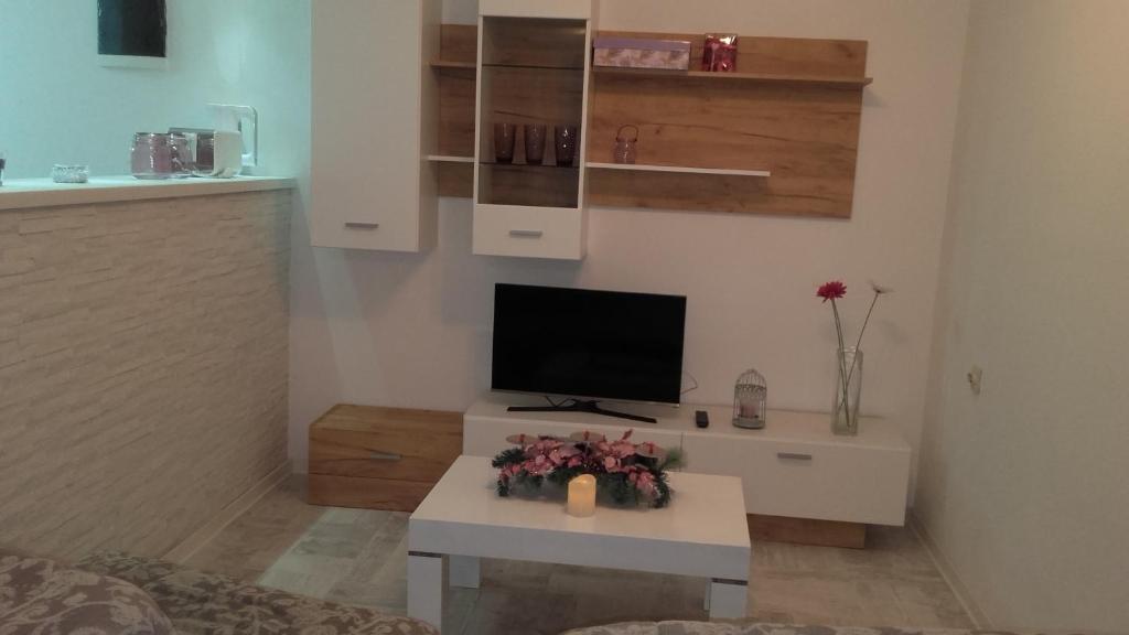a living room with a tv and a table with flowers at Villa Snow Queen Kopaonik in Kopaonik