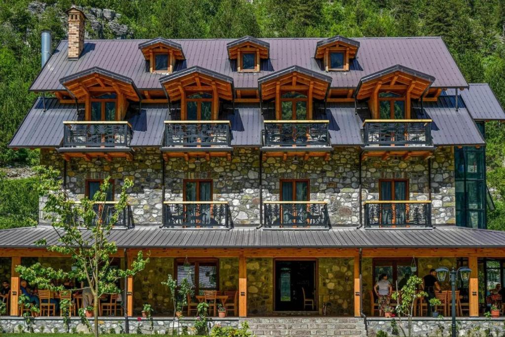 a large wooden house with a metal roof at Golden Villa in Theth
