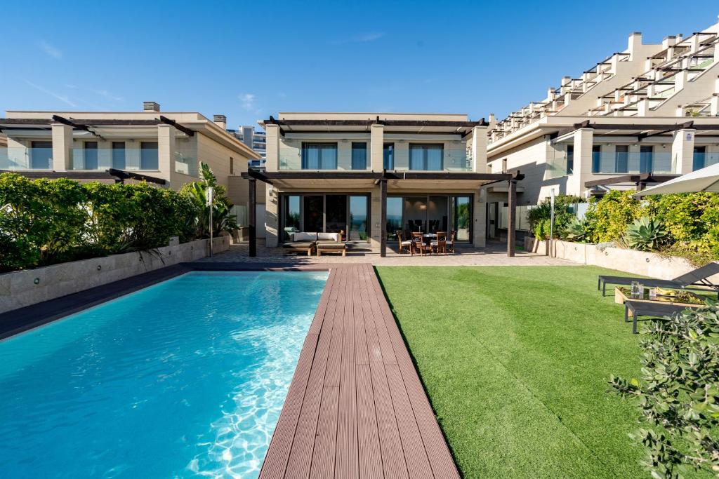 a swimming pool in the backyard of a house at Mediterranean Beach in Arenales del Sol
