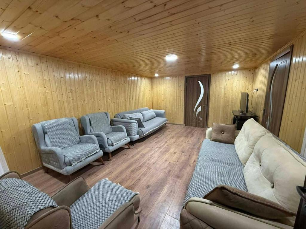 a living room with couches and chairs in a room at Ortabatumis house in Ch'aisubani