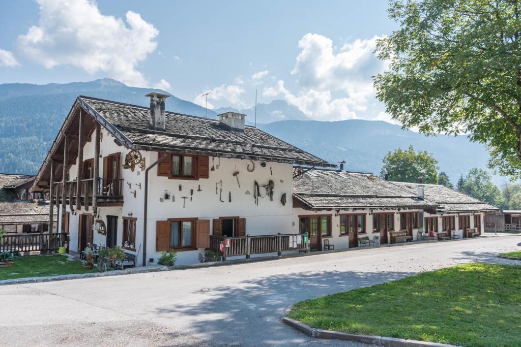 a large white building with mountains in the background at Appartamento Adamello 12 in Pinzolo