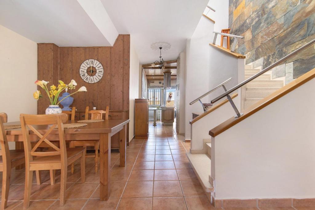 a dining room with a table and chairs and a staircase at Casa La Herradura in Telde