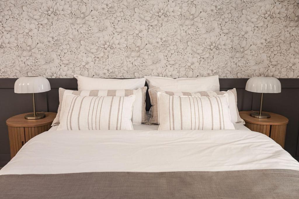 a bedroom with a white bed with two lamps at Osterøy Minihotell in Lonevåg