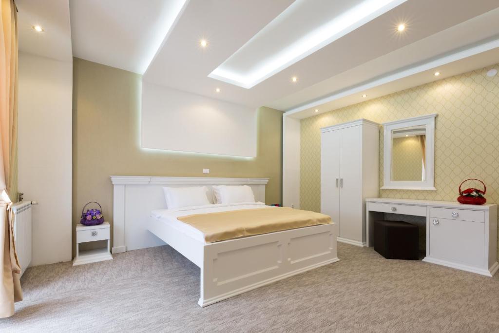 1 dormitorio con cama blanca y espejo en Hotel Sabor, en Belgrado