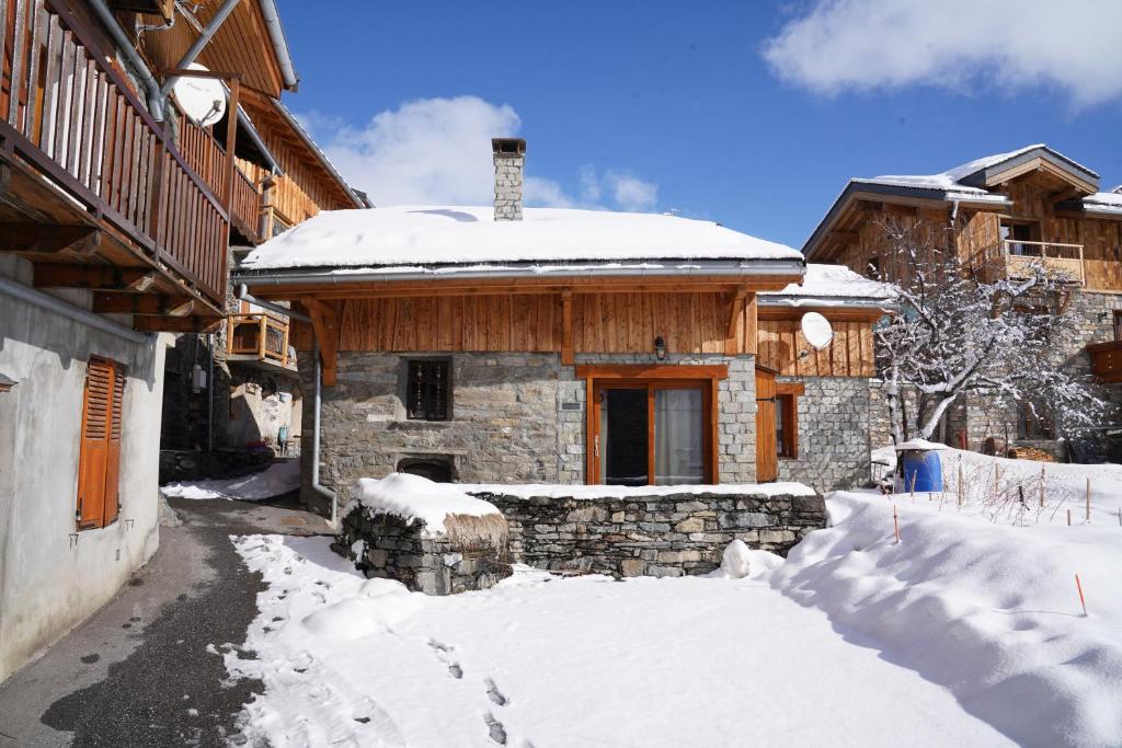 a house with snow on the ground in front of it at Chalet La Petite Maison in Saint-Marcel