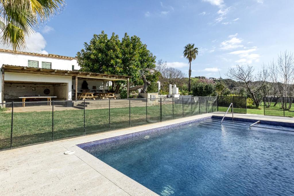 a swimming pool in front of a house at Masia Cal Ros in S'agaro