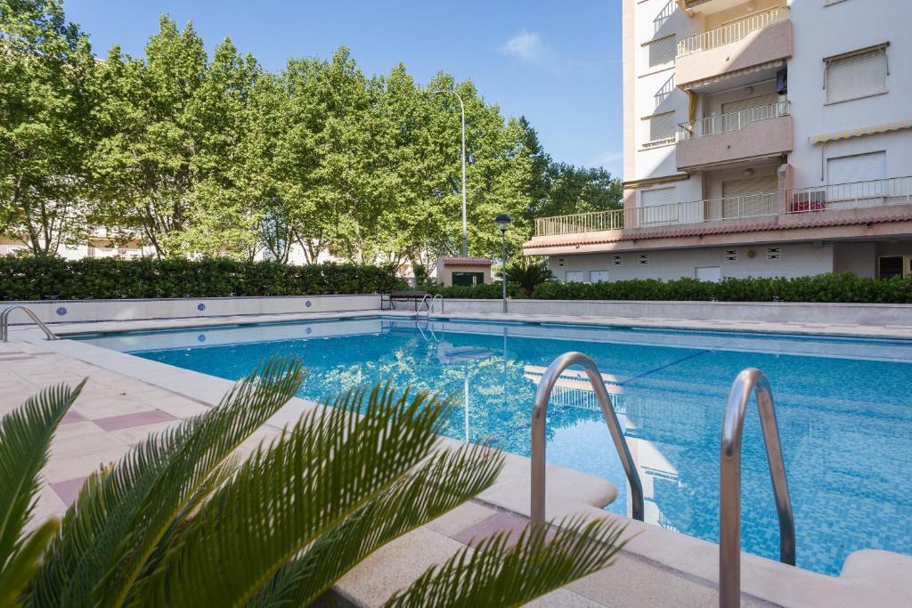 a swimming pool in front of a building at Jardín X in Gandía