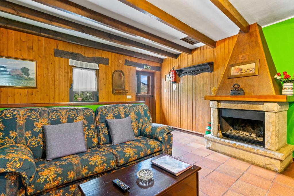 ein Wohnzimmer mit Sofa und Kamin in der Unterkunft Lorences B in Caunedo