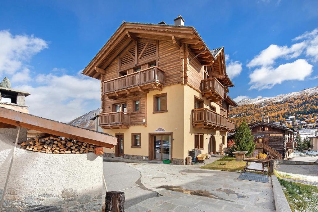 a building with a pile of fire wood in front of it at Livigno Wooden House in Livigno