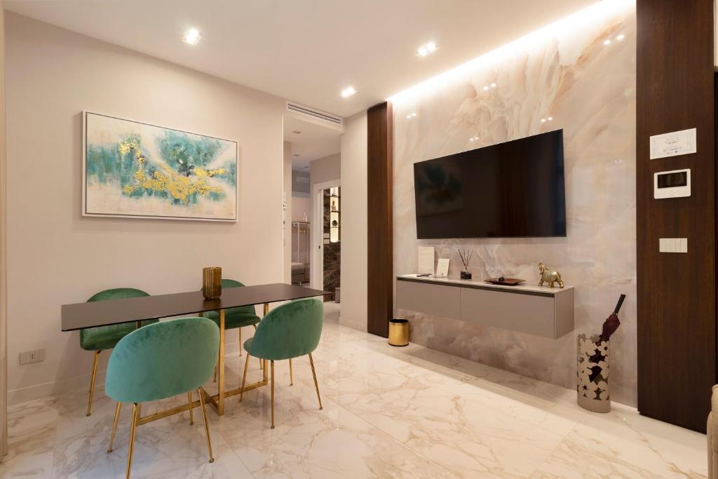 a living room with a table and chairs and a television at Ginex Luxury Suite, Trani in Trani