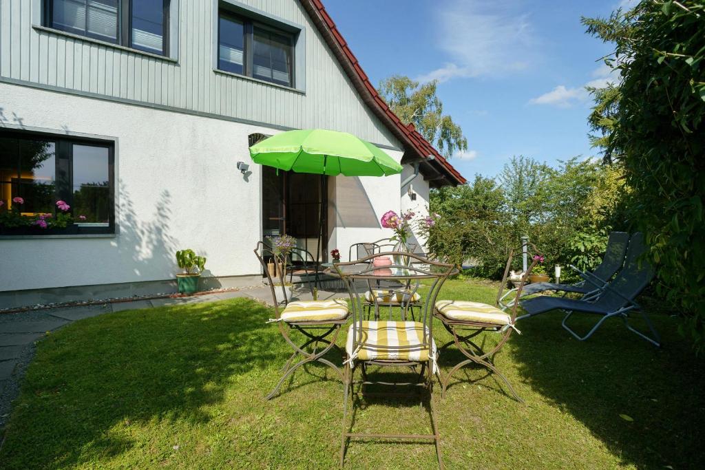 a table and chairs with a green umbrella at Ferienwohnung Sonnenblick in Putbus