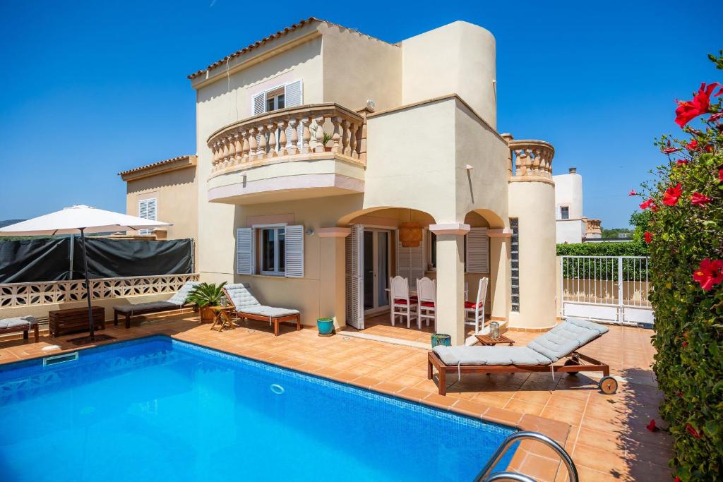 a villa with a swimming pool in front of a house at Villa Sion in Cala Mendia