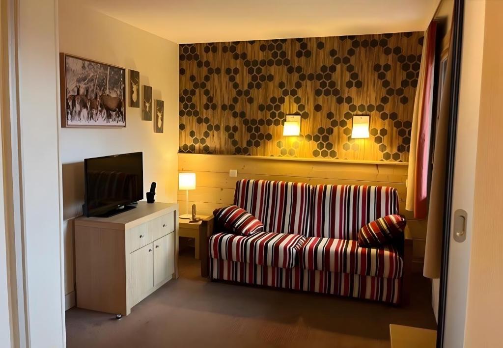 a living room with a couch and a television at Appartement Soldanelle in La Plagne Tarentaise