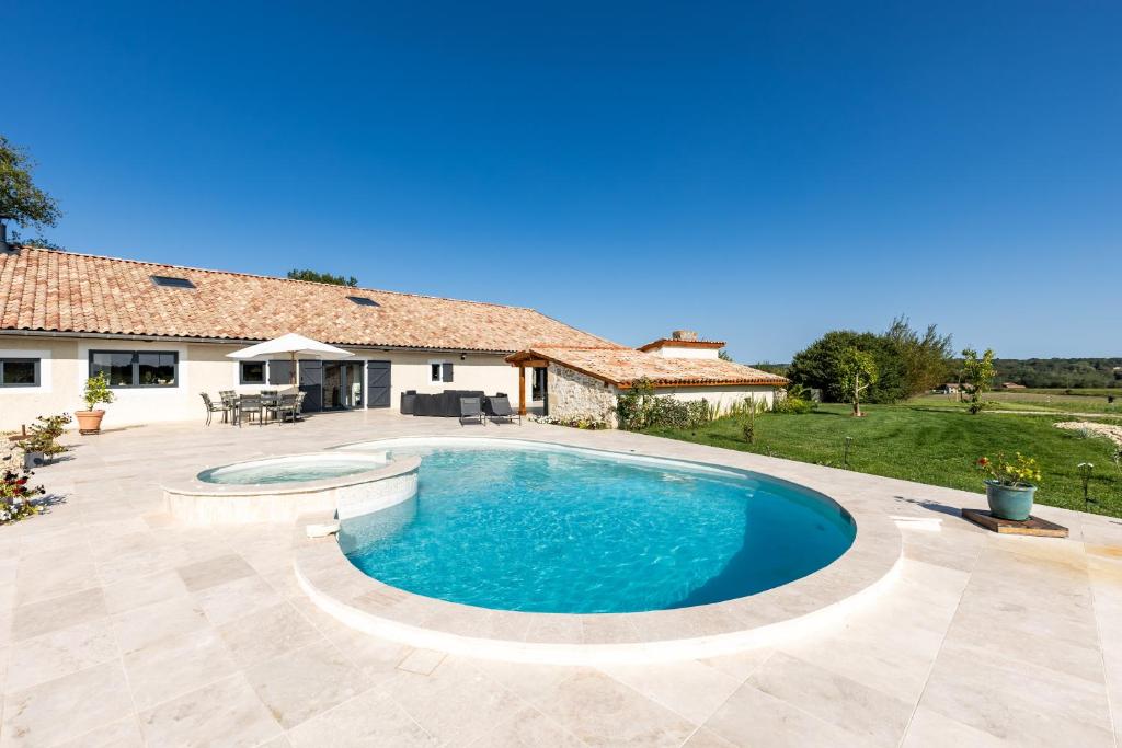 an image of a swimming pool in front of a house at Le Palmier Exotique - Bazas in Bazas