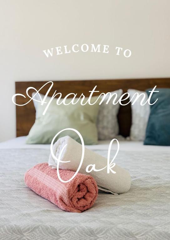 a towel on a bed with the words welcome to apartment dad at Apartment Oak Root in Mostar