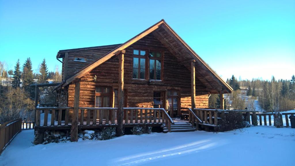 a log cabin in the snow with a snow covered yard at Cabana Belis Dealu Negru in Beliş