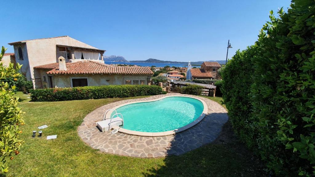 a swimming pool in a yard next to a house at Villetta Caron in Olbia