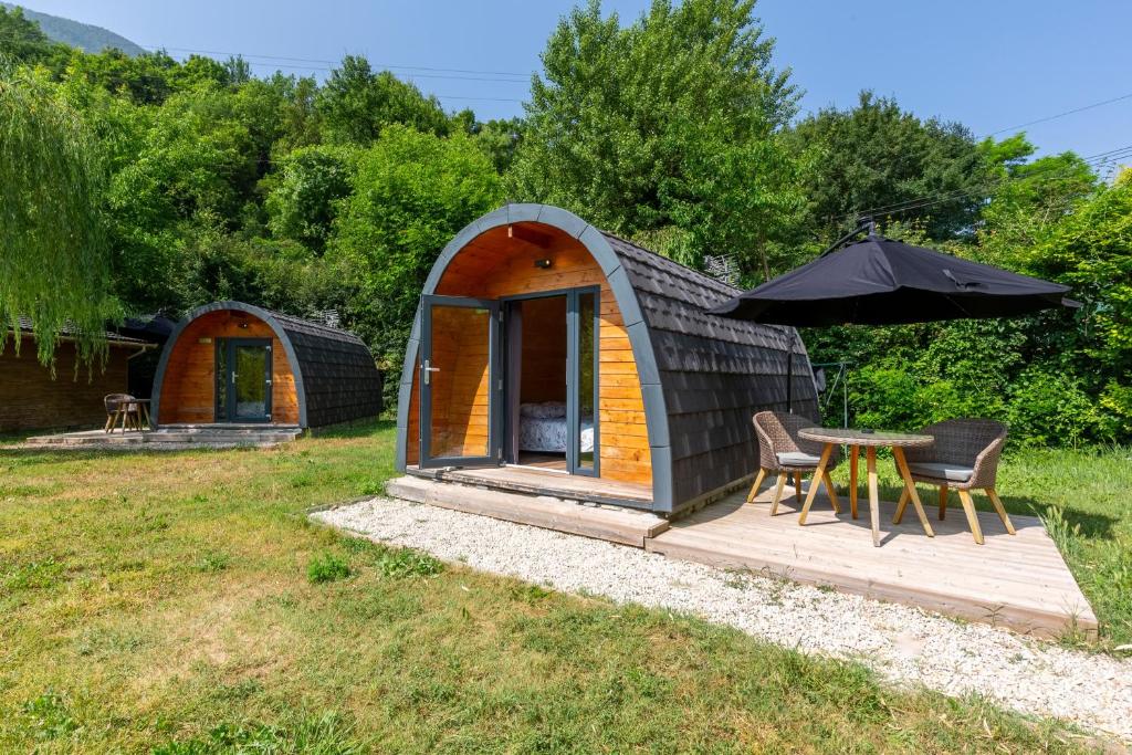 a small cabin with a table and an umbrella at Pod nature terrasse privée insolite in Touët-sur-Var