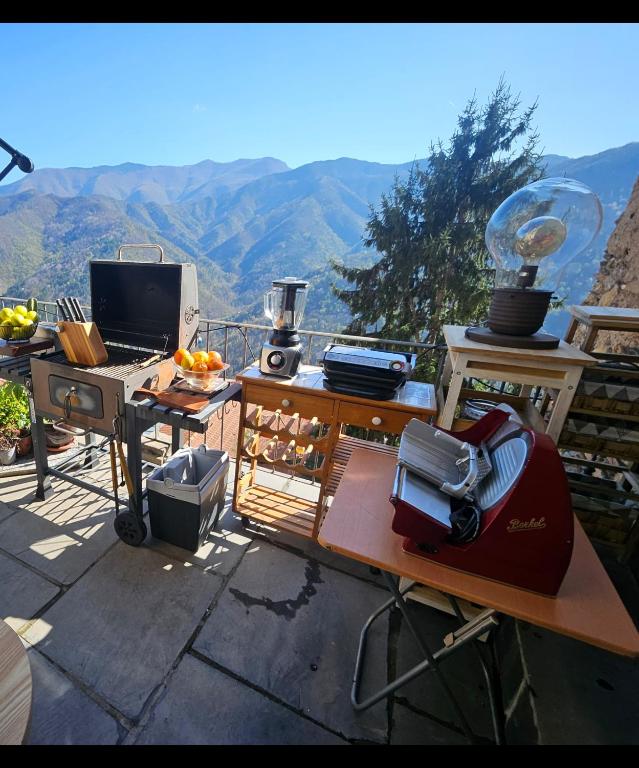 a desk with a computer on a balcony with mountains in the background at La Torre Medievale in Triora