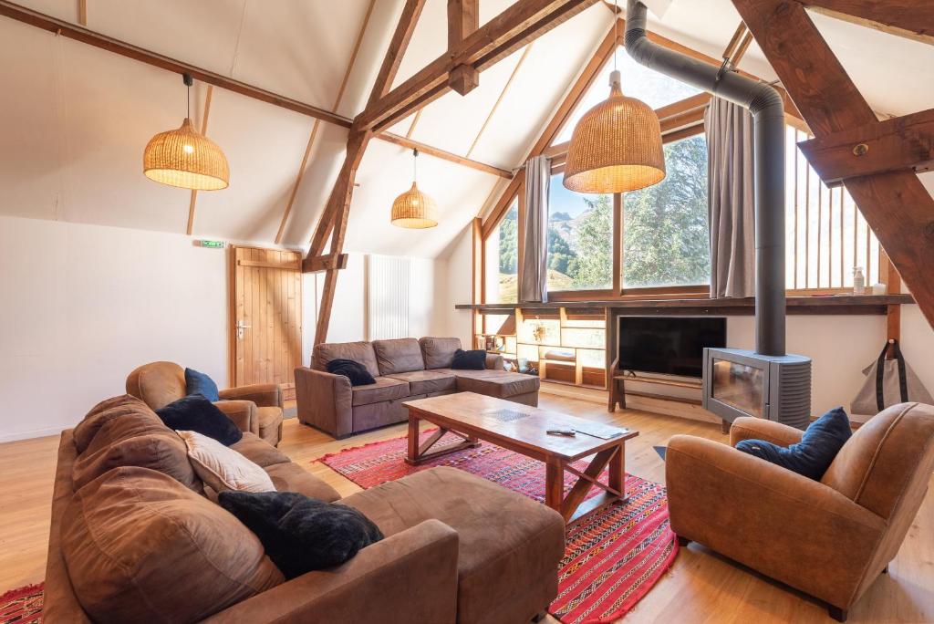 a large living room with couches and a fireplace at Chalet Confortable 14 voyageurs in Urdos