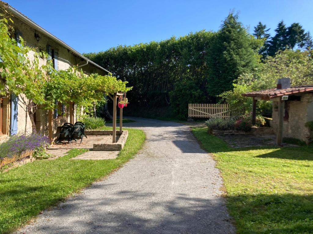 a path leading into a garden with a house at Chez Bonneau in Nantiat