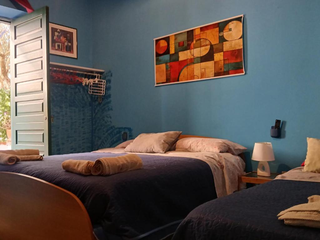 a bedroom with two beds and a painting on the wall at La capannina cilento num 11 in San Marco di Castellabate