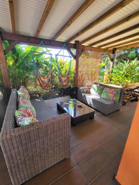 an outdoor patio with couches and a table at Gîte KAZ' A TYKA jacuzzi privatif in Saint-François