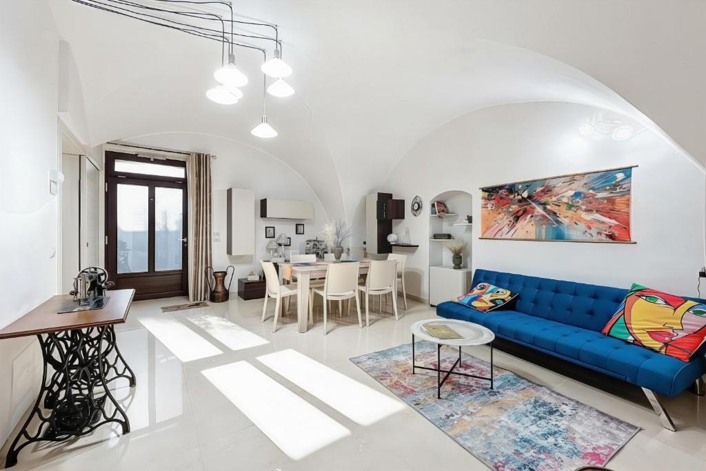 a living room with a blue couch and a dining room at Mikiami Semplicemente Accogliente in Monte SantʼAngelo