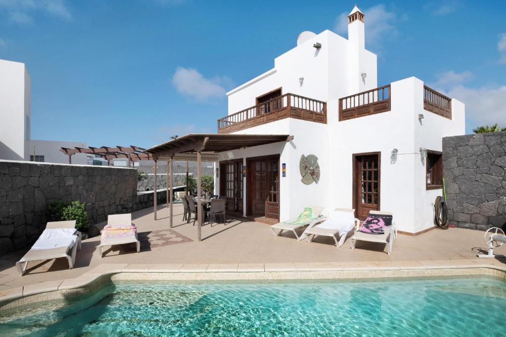 a villa with a swimming pool and a house at Serendipity in Playa Blanca