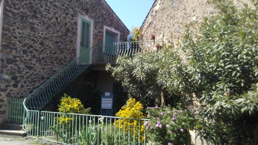 a building with a staircase and flowers in front of it at La Coustouline in Lacoste