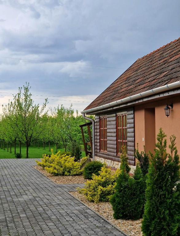 a house with a brick driveway next to a building at Szilvaliget Vendégház in Tolcsva