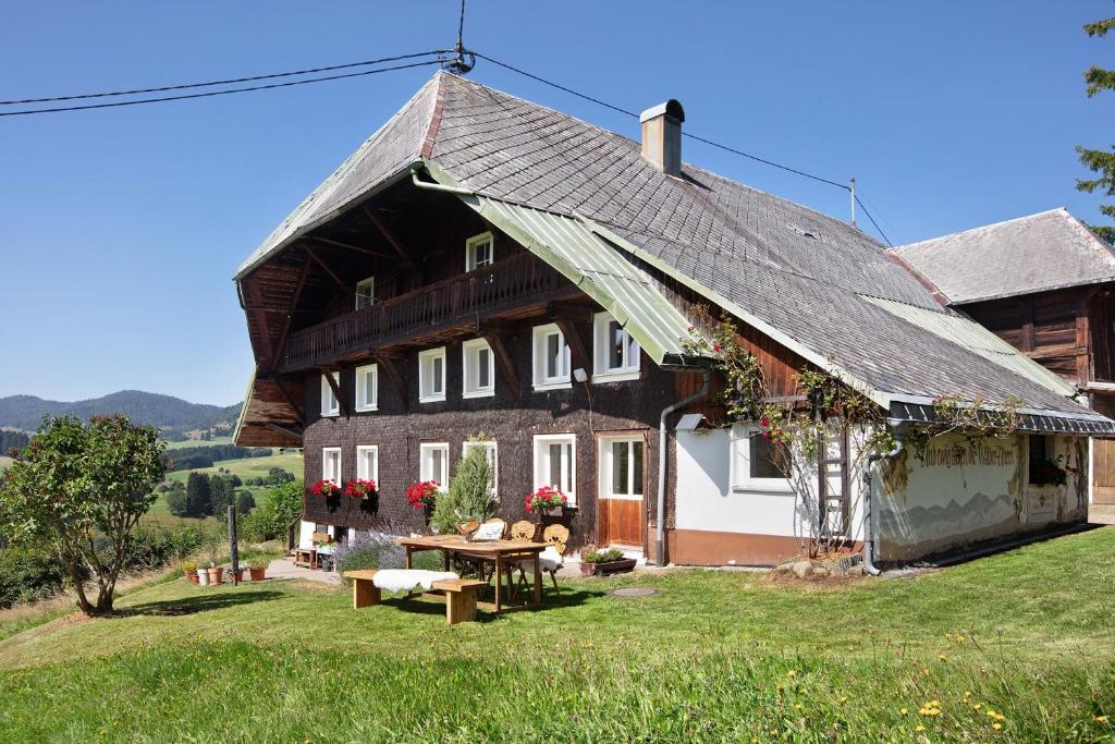 a large wooden house with a table in front of it at Black Forest Woods in Bernau im Schwarzwald