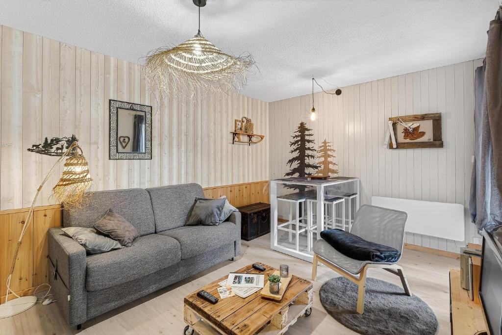 a living room with a couch and a table at Studio 5 Pers, rdc, pied des pistes in Saint-Michel-de-Chaillol