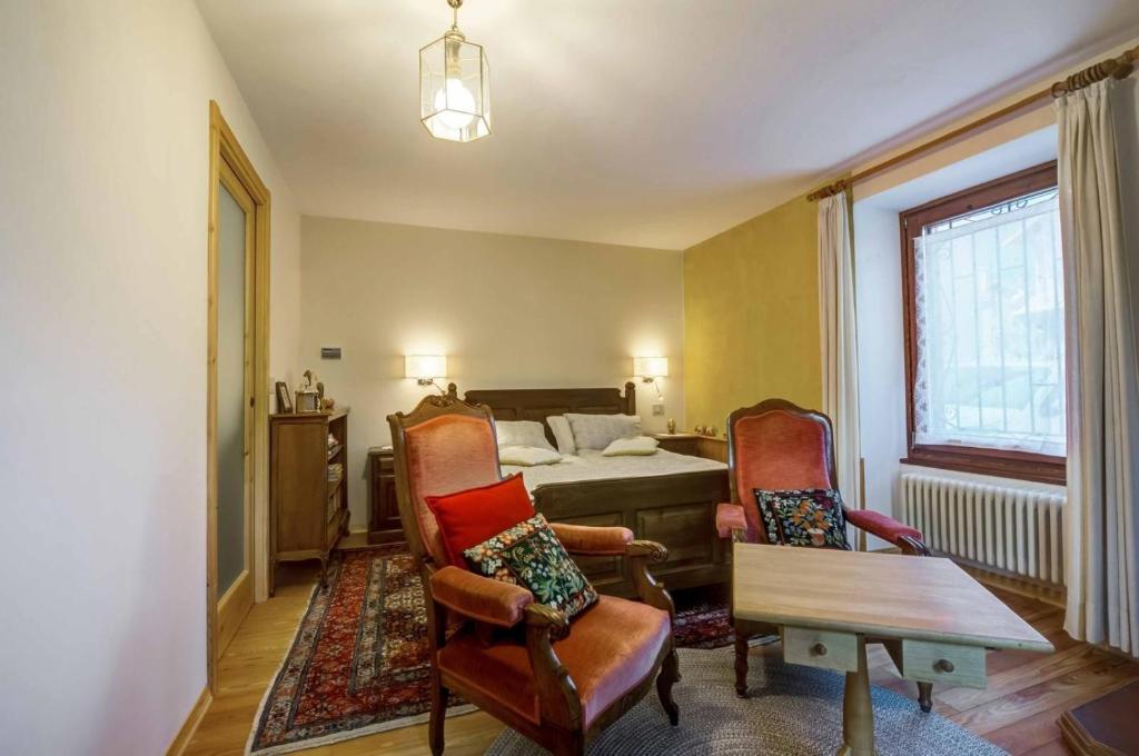 a living room with two chairs and a bed at Il Pellegrino in Issogne