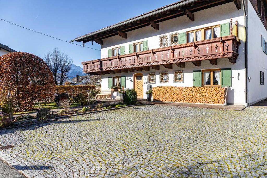 a building with a balcony on a cobblestone street at Ferienwohnungen Arnspitz in Krün in Krün