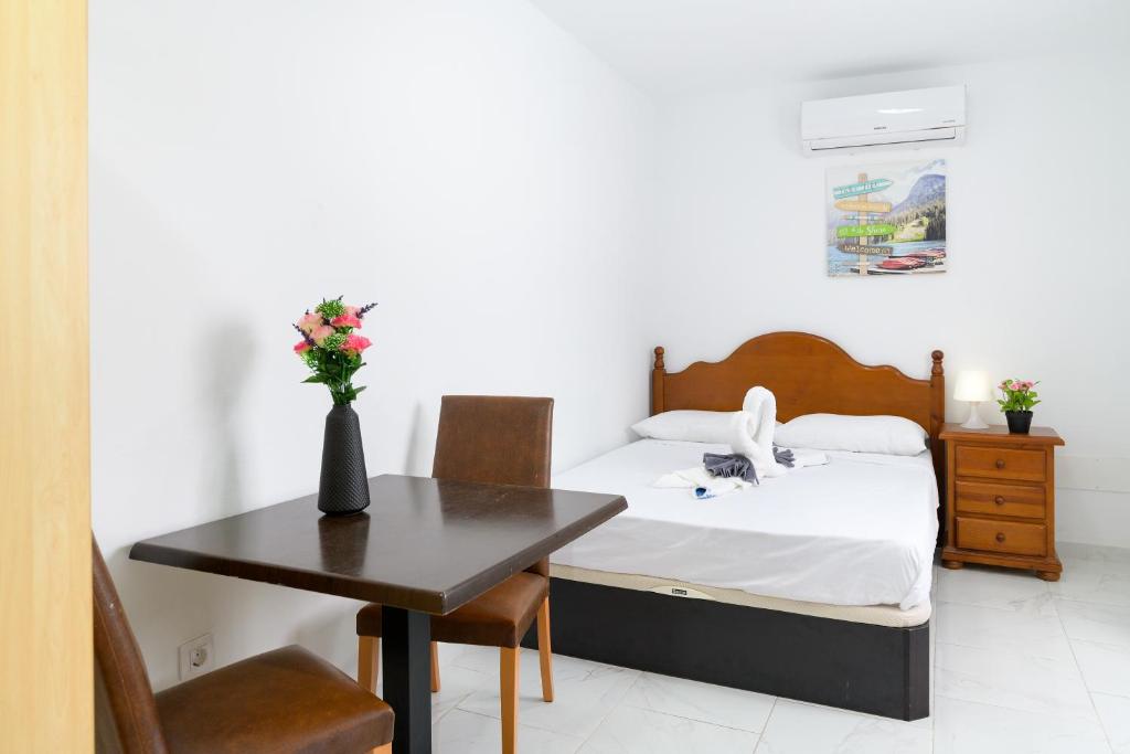 a bedroom with a bed and a desk and a table at Kays studio in Puerto del Carmen