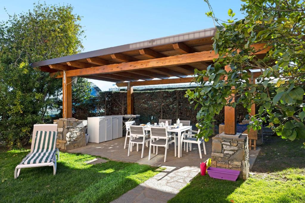 a patio with a table and chairs under a pergola at Home Charlene parking e patio in Albenga