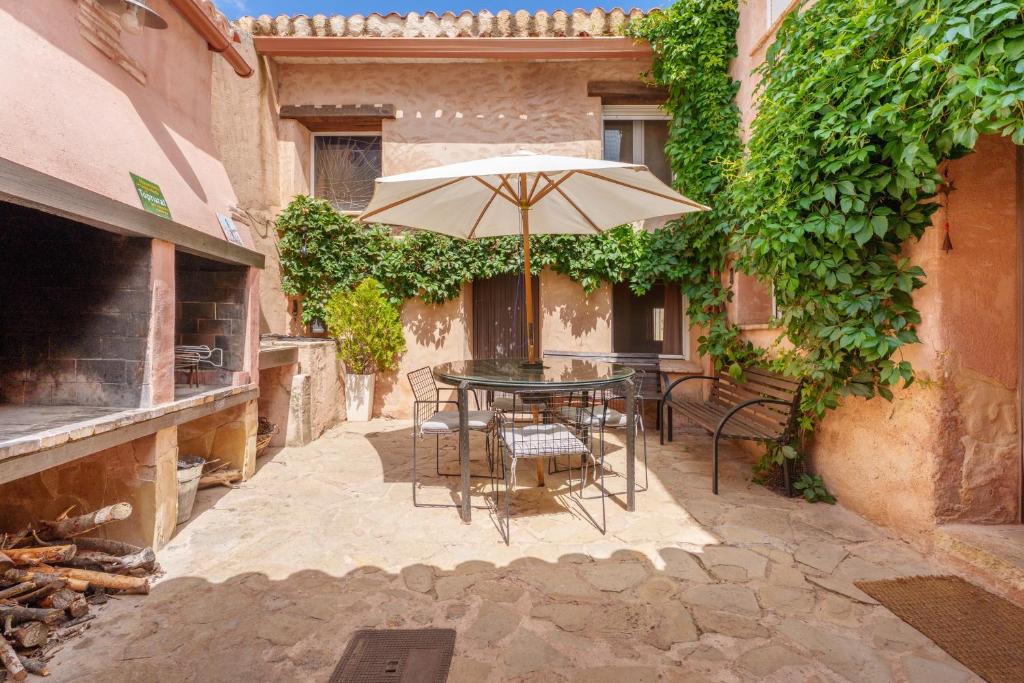 a patio with a table and an umbrella at La Casica del Sol in Requena