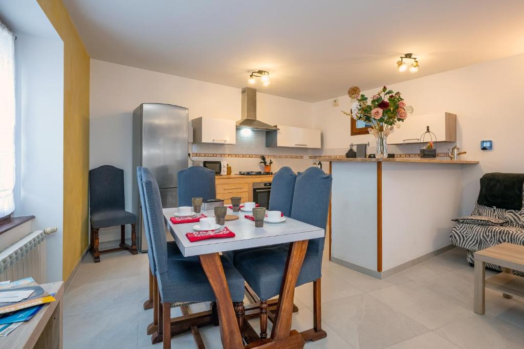 a kitchen and dining room with a table and chairs at Chez Lulu in Brézins