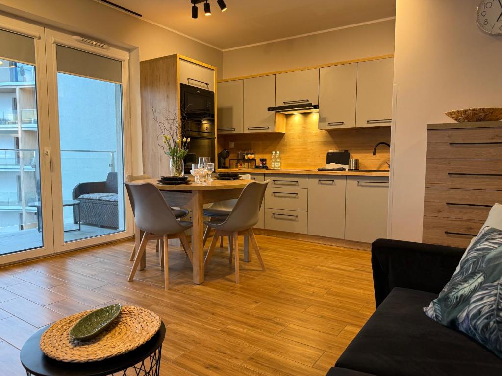 a kitchen and living room with a table and chairs at Kutnowska Perła in Kutno