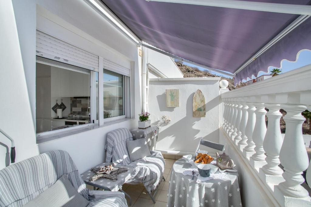 a balcony with two chairs and a table at Estrella Del Mar Amazing Loft Casa in Mogán