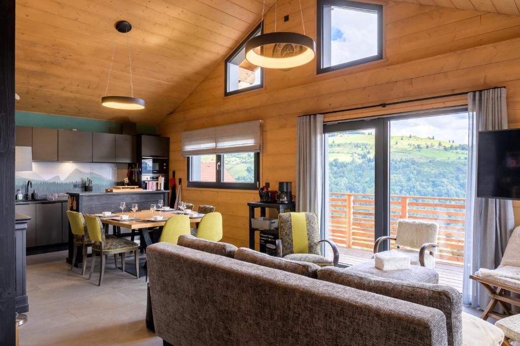 a living room with a couch and a dining room at Le chalet Amélie in La Bresse