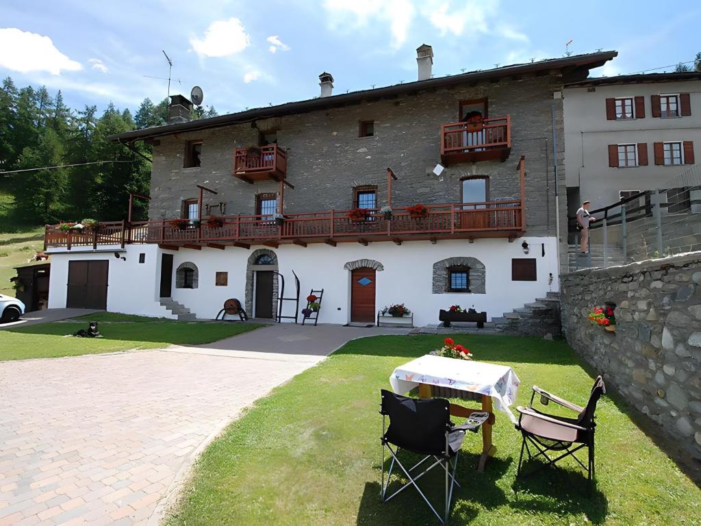 a house with a table and chairs in front of it at Maison Cerise Pila in Gressan